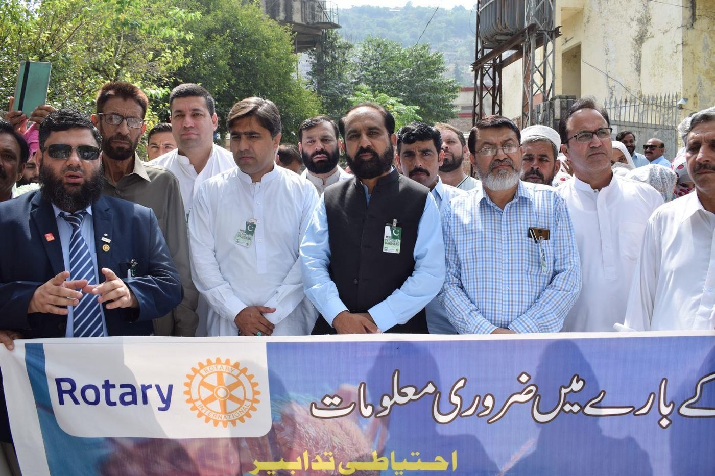 Rotarians and community leaders marching behind a Rotary polio awareness banner