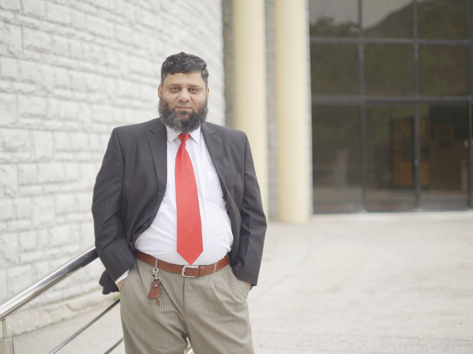 Dr. Ahmed Ejaz in a dark suit and red tie