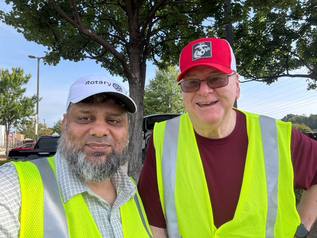 Dr. Ahmed Ejaz and a fellow Rotarian in safety vests at a volunteer project