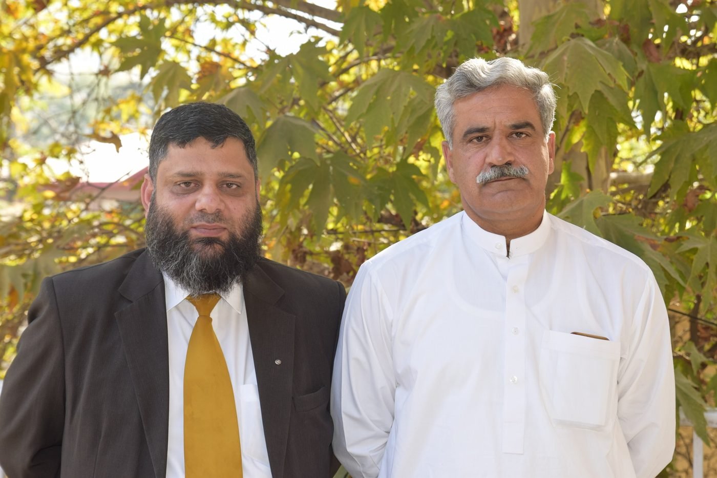 Dr. Ahmed Ejaz outdoors with a friend under autumn trees
