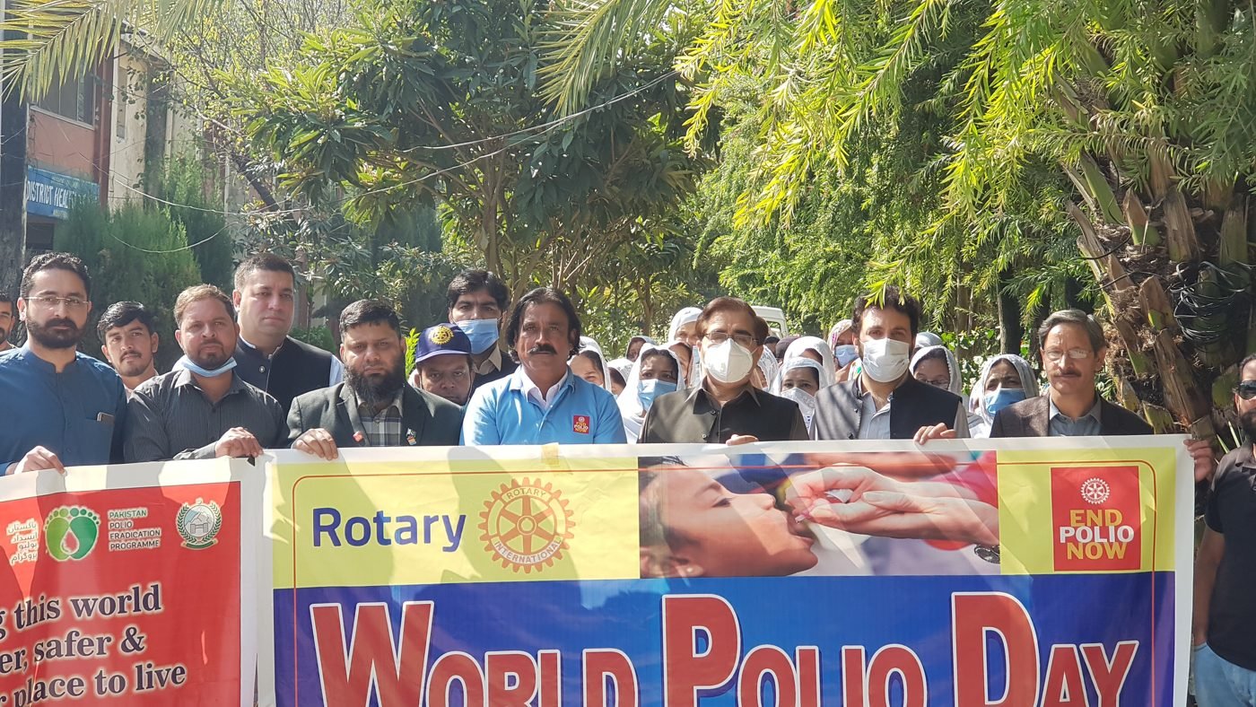 Rotarians and community members holding a World Polio Day banner